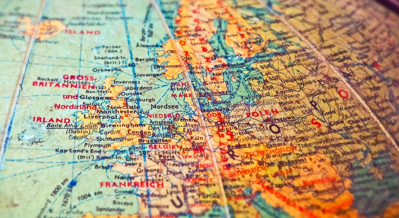 Golden bullion bars representing safe haven gold on top of a world map