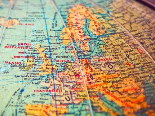 Golden bullion bars representing safe haven gold on top of a world map
